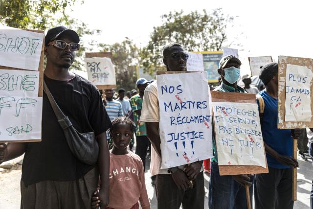 Students and activists hold placards during a demonstration demanding an end to police blunders and bring justice to the victims in Dakar on February 21, 2026. Students and pupils organizations, as well as activists, marched in Dakar on Saturday to “demand an end to police blunders and bring justice to the victims,” following the death of a student during a police operation at a university in the capital in early February. Abdoulaye Ba, a second-year medical student, died on February 9 on the campus of Cheikh Anta Diop University (UCAD) during a police operation, after several days of demonstrations and clashes between police and students protesting a reform of scholarship payments and demanding the settlement of arrears. (Photo by PATRICK MEINHARDT / AFP)