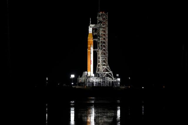 (FILES) The Space Launch System (SLS) rocket and the Orion spacecraft, integrated for the Artemis II mission, are seen at Launch Pad 39B at the Kennedy Space Center in Cape Canaveral, Florida, on February 1, 2026 ahead of the first crewed mission to the Moon in more than 50 years. NASA chief Jared Isaacman on February 21, 2026, ruled out a March launch for Artemis 2, the first crewed flyby mission to the Moon in more than 50 years, citing technical issues. Workers detected a problem with helium flow to the massive SLS rocket that will "take the March launch window out of consideration," Issacman said in a post on X. (Photo by Miguel J. Rodriguez Carrillo / AFP)