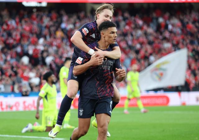 SL Benfica's Danish defender #06 Alexander Bah (R) celebrates with his teammate SL Benfica's Norwegian forward #21 Andreas Schjelderup after scoring the opening goal during the Portuguese League football match between SL Benfica and AVS Futebol SAD at Estadio da Luz in Lisbon on February 21, 2026. (Photo by PATRICIA DE MELO MOREIRA / AFP)