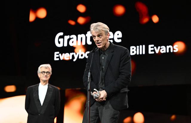 Jury President and German director Wim Wenders presents British film director Grant Gee with the Silver Bear for Best Director for his film "Everybody Digs Bill Evans" during the Award Ceremony of the 76th Berlinale, Europe's first major film festival of the year, in Berlin on February 21, 2026. The 76th Berlin Film Festival draws to a close after 10 days, with 22 films in competition. (Photo by RALF HIRSCHBERGER / AFP)