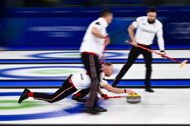 Canada's Brad Jacobs (C) throws a stone during the curling men's gold medal game between Great Britain and Canada during the Milano Cortina 2026 Winter Olympic Games at the Cortina Curling Olympic Stadium in Cortina d’Ampezzo on February 21, 2026. (Photo by Marco BERTORELLO / AFP)