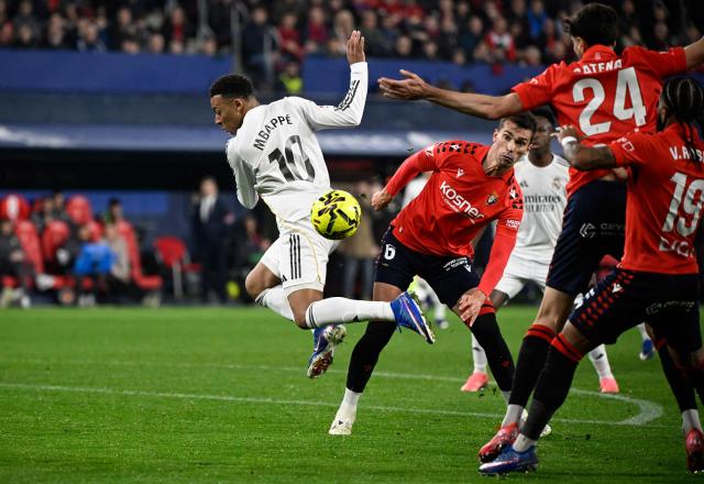 Real Madrid's French forward #10 Kylian Mbappe and Osasuna's Spanish midfielder #06 Lucas Torro Marset fight for the ball during the Spanish league football match between CA Osasuna and Real Madrid CF at El Sadar Stadium in Pamplona on February 21, 2026. (Photo by ANDER GILLENEA / AFP)