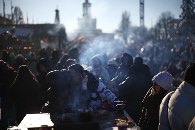 A couple embrance at a Masnytsya (Shrovetide) celebration, a traditional Eastern Slavic religious and folk holiday that marks the end of winter and the beginning of spring, at the Expocentre of Ukraine in Kyiv on February 21, 2024, amid the Russian invasion of Ukraine. (Photo by HENRY NICHOLLS / AFP)