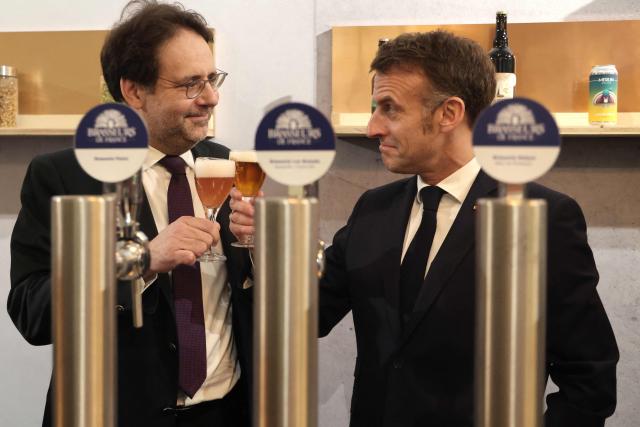 France's President Emmanuel Macron toasts with Brewers of France's president Matthias Fekl (L), during the opening of the International Agricultural Show (Salon de l'Agriculture) at Paris Expo Porte de Versailles in Paris on February 21, 2026. (Photo by Ludovic MARIN / POOL / AFP)