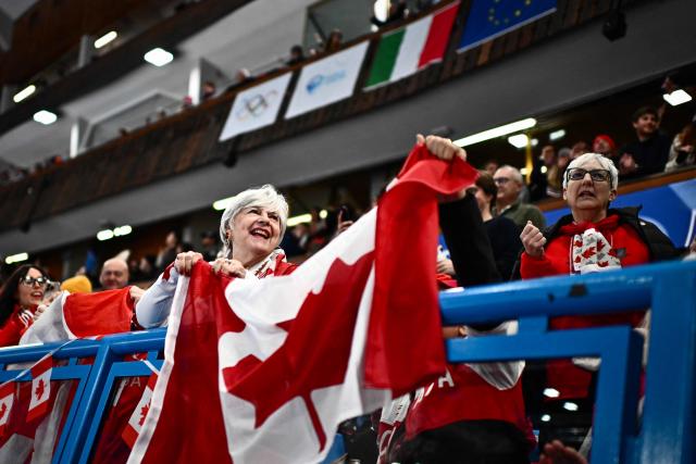 Canadian curling fans cheer on their team during the curling men's gold medal game between Great Britain and Canada during the Milano Cortina 2026 Winter Olympic Games at the Cortina Curling Olympic Stadium in Cortina d’Ampezzo on February 21, 2026. (Photo by Marco BERTORELLO / AFP)