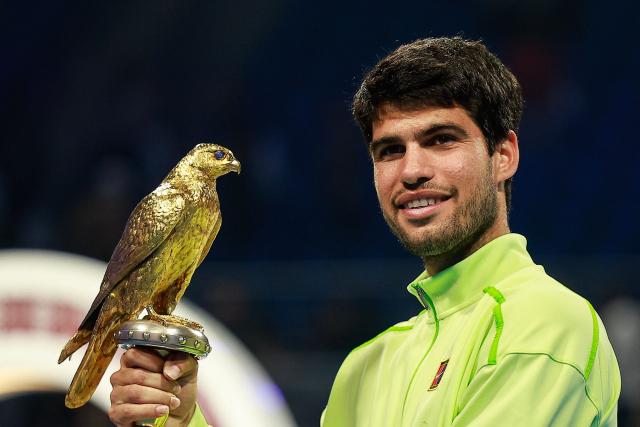 Spain's Carlos Alcaraz celebrates with the trophy after winning his men’s singles final match against France's Arthur Fils at the Qatar Open tennis tournament in Doha on February 21, 2026. (Photo by Karim JAAFAR / AFP)