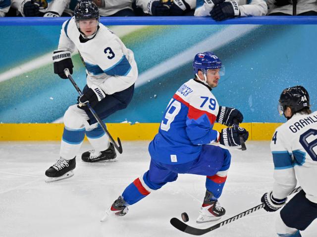 Finland's #03 Olli Maatta (L), fights for the puck with Slovakia's #79 Libor Hudacek and Finland's #64 Mikael Granlund during the men's bronze medal ice hockey match between Slovakia and Finland at the Milano Santagiulia Ice Hockey Arena during the Milano Cortina 2026 Winter Olympic Games in Milan, on February 21, 2026. (Photo by Alexander NEMENOV / AFP)