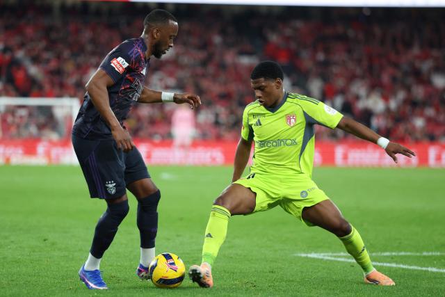 SL Benfica's Belgian forward #11 Dodi Lukebakio (L) and AVS' Colombian forward #14 Oscar Perea fight for the ball during the Portuguese League football match between SL Benfica and AVS Futebol SAD at Estadio da Luz in Lisbon on February 21, 2026. (Photo by PATRICIA DE MELO MOREIRA / AFP)