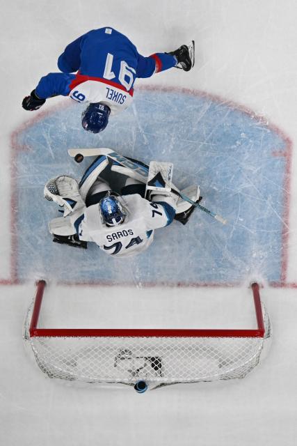 Slovakia's #91 Matus Sukel and Finland's #74 Juuse Saros fight for the puck during the men's bronze medal ice hockey match between Slovakia and Finland at the Milano Santagiulia Ice Hockey Arena during the Milano Cortina 2026 Winter Olympic Games in Milan, on February 21, 2026. (Photo by Alexander NEMENOV / AFP)
