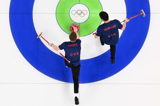 Britain's Bobby Lammie (L) delivers a stone next to Britain's Hammy Mcmillan during the curling men's gold medal game between Great Britain and Canada during the Milano Cortina 2026 Winter Olympic Games at the Cortina Curling Olympic Stadium in Cortina d’Ampezzo on February 21, 2026. (Photo by Franзois-Xavier MARIT / AFP)