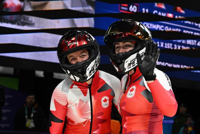 Canada's Melissa Lotholz and Canada's Kelsey Mitchell react after competing in the bobsleigh women's 2-woman heat 4 at Cortina Sliding Centre during the Milano Cortina 2026 Winter Olympic Games in Cortina d'Ampezzo on February 21, 2026. (Photo by Tiziana FABI / AFP)