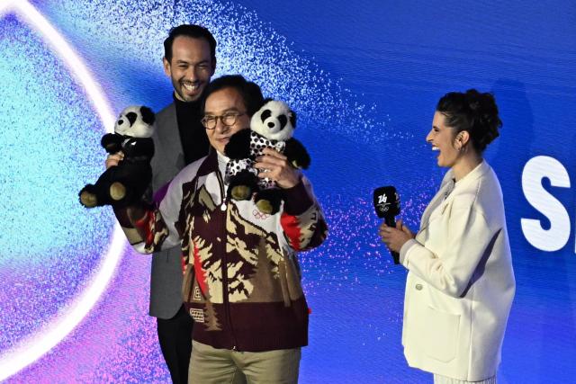 Hong Kong actor Jackie Chan (C) holds panda plushies during an inverview at the figure skating exhibition gala during the Milano Cortina 2026 Winter Olympic Games at Milano Ice Skating Arena in Milan on February 21, 2026. (Photo by Gabriel BOUYS / AFP)