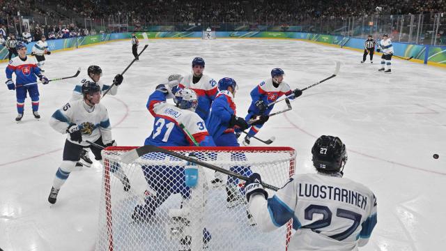 Finland's #15 Anton Lundell, Slovakia's #31 Samuel Hlavaj, Slovakia's #28 Martin Gernat, Slovakia's #08 Oliver Okuliar and Finland's #27 Eetu Luostarinen fight for the puck during the men's bronze medal ice hockey match between Slovakia and Finland at the Milano Santagiulia Ice Hockey Arena during the Milano Cortina 2026 Winter Olympic Games in Milan, on February 21, 2026. (Photo by Alexander NEMENOV / POOL / AFP)