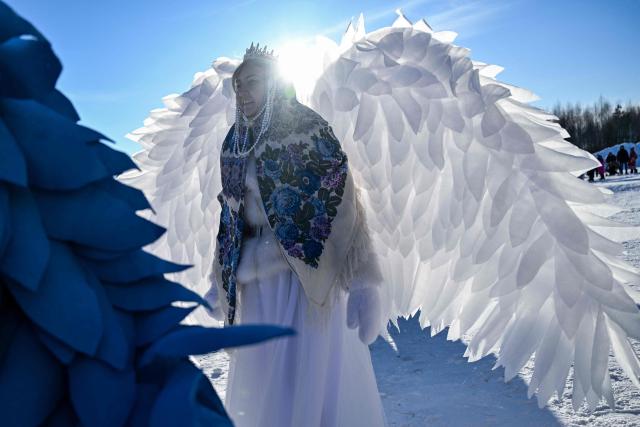 A woman wearing a costume attends celebrations of "Maslenitsa", the eastern Slavic Shrovetide in the village of Nikola-Lenivets,Kaluga region, some 220 km (140 miles) outside Moscow, on February 21, 2026, before the burning of a wooden structure called "Burning Heart" created by Russian artist Nikolay Polissky. Shrovetide or Maslenitsa is an ancient farewell ceremony to winter, traditionally celebrated in Belarus, Russia and Ukraine and involves the burning of a large effigy. (Photo by HECTOR RETAMAL / AFP)