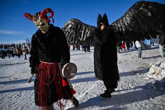 People wearing costumes attend celebrations of "Maslenitsa", the eastern Slavic Shrovetide in the village of Nikola-Lenivets,Kaluga region, some 220 km (140 miles) outside Moscow, on February 21, 2026, before the burning of a wooden structure called "Burning Heart" created by Russian artist Nikolay Polissky. Shrovetide or Maslenitsa is an ancient farewell ceremony to winter, traditionally celebrated in Belarus, Russia and Ukraine and involves the burning of a large effigy. (Photo by HECTOR RETAMAL / AFP)