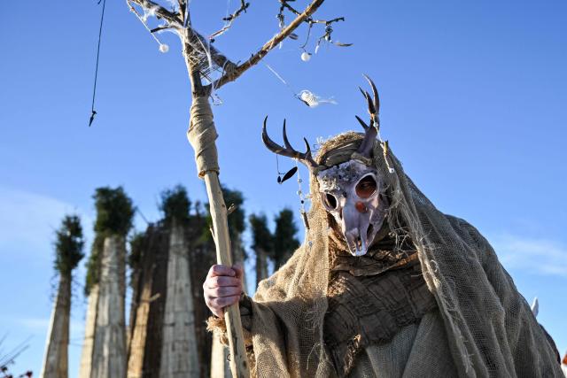 A man wearing a costume attends celebrations of "Maslenitsa", the eastern Slavic Shrovetide in the village of Nikola-Lenivets,Kaluga region, some 220 km (140 miles) outside Moscow, on February 21, 2026, before the burning of a wooden structure called "Burning Heart" created by Russian artist Nikolay Polissky. Shrovetide or Maslenitsa is an ancient farewell ceremony to winter, traditionally celebrated in Belarus, Russia and Ukraine and involves the burning of a large effigy. (Photo by HECTOR RETAMAL / AFP)