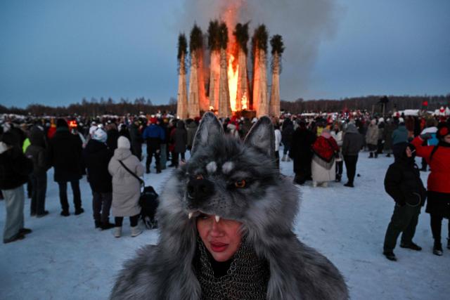 Spectators watch the burning of the 'Burning Heart", a wooden structure created by Russian artist Nikolay Polissky, during celebrations of "Maslenitsa", the eastern Slavic Shrovetide in the village of Nikola-Lenivets, Kaluga region, some 220 km (140 miles) outside Moscow, on February 21, 2026. Shrovetide or Maslenitsa is an ancient farewell ceremony to winter, traditionally celebrated in Belarus, Russia and Ukraine and involves the burning of a large effigy. (Photo by HECTOR RETAMAL / AFP)