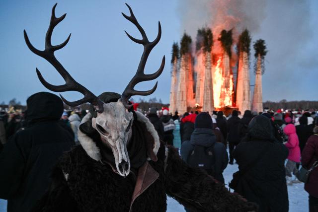 Spectators watch the burning of the 'Burning Heart", a wooden structure created by Russian artist Nikolay Polissky, during celebrations of "Maslenitsa", the eastern Slavic Shrovetide in the village of Nikola-Lenivets, Kaluga region, some 220 km (140 miles) outside Moscow, on February 21, 2026. Shrovetide or Maslenitsa is an ancient farewell ceremony to winter, traditionally celebrated in Belarus, Russia and Ukraine and involves the burning of a large effigy. (Photo by HECTOR RETAMAL / AFP)