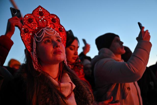 Spectators watch the burning of the 'Burning Heart", a wooden structure created by Russian artist Nikolay Polissky, during celebrations of "Maslenitsa", the eastern Slavic Shrovetide in the village of Nikola-Lenivets, Kaluga region, some 220 km (140 miles) outside Moscow, on February 21, 2026. Shrovetide or Maslenitsa is an ancient farewell ceremony to winter, traditionally celebrated in Belarus, Russia and Ukraine and involves the burning of a large effigy. (Photo by HECTOR RETAMAL / AFP)