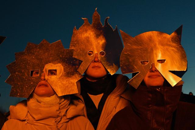 TOPSHOT - Spectators wearing costumes watch the burning of the 'Burning Heart", a wooden structure created by Russian artist Nikolay Polissky, during celebrations of "Maslenitsa", the eastern Slavic Shrovetide in the village of Nikola-Lenivets, Kaluga region, some 220 km (140 miles) outside Moscow, on February 21, 2026. Shrovetide or Maslenitsa is an ancient farewell ceremony to winter, traditionally celebrated in Belarus, Russia and Ukraine and involves the burning of a large effigy. (Photo by HECTOR RETAMAL / AFP)