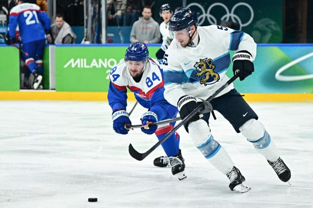 Slovakia's #84 Pavol Regenda fights for the puck with Finland's #55 Rasmus Ristolainen during the men's bronze medal ice hockey match between Slovakia and Finland at the Milano Santagiulia Ice Hockey Arena during the Milano Cortina 2026 Winter Olympic Games in Milan, on February 21, 2026. (Photo by JULIEN DE ROSA / AFP)