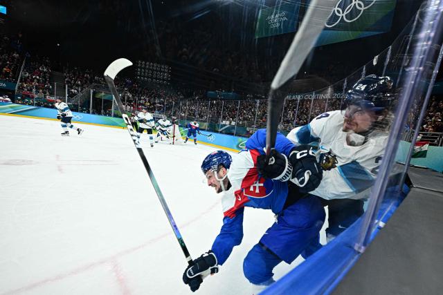 Slovakia's #08 Oliver Okuliar (L) collides with Finland's #24 Roope Hintz during the men's bronze medal ice hockey match between Slovakia and Finland at the Milano Santagiulia Ice Hockey Arena during the Milano Cortina 2026 Winter Olympic Games in Milan, on February 21, 2026. (Photo by JULIEN DE ROSA / AFP)