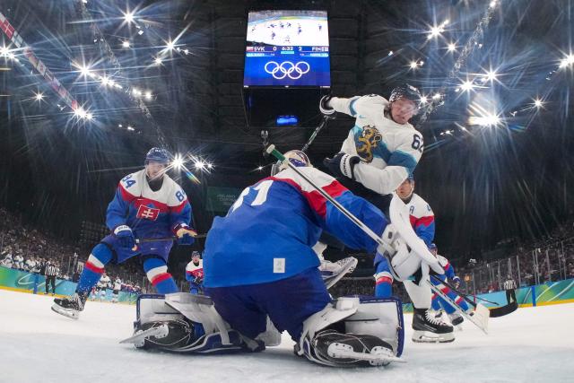 Slovakia's #31 goalkeeper Samuel Hlavaj fights with Finland's #62 Artturi Lehkonen next to Slovakia's #84 Pavol Regenda during the men's bronze medal ice hockey match between Slovakia and Finland at the Milano Santagiulia Ice Hockey Arena during the Milano Cortina 2026 Winter Olympic Games in Milan, on February 21, 2026. (Photo by POOL / AFP)