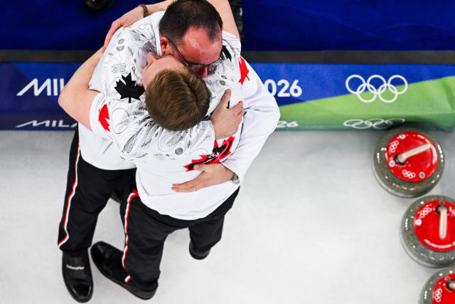 Team Canada celebrate after defeating team GB in the curling men's gold medal game between Great Britain and Canada during the Milano Cortina 2026 Winter Olympic Games at the Cortina Curling Olympic Stadium in Cortina d’Ampezzo on February 21, 2026. (Photo by Franзois-Xavier MARIT / AFP)