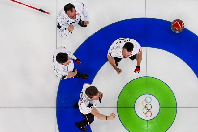 Team Canada celebrate after defeating team GB in the curling men's gold medal game between Great Britain and Canada during the Milano Cortina 2026 Winter Olympic Games at the Cortina Curling Olympic Stadium in Cortina d’Ampezzo on February 21, 2026. (Photo by Franзois-Xavier MARIT / AFP)