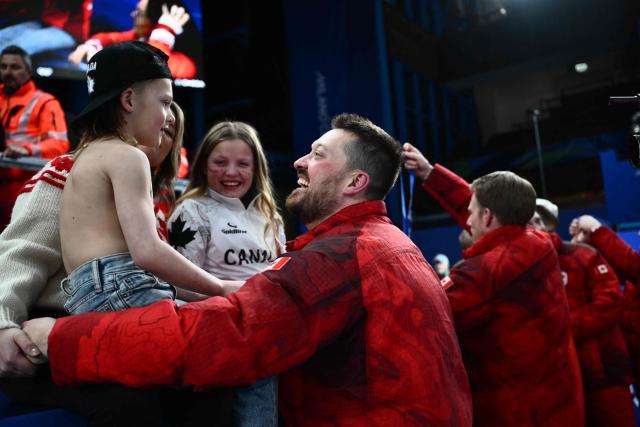 Canada's Ben Hebert celebrates victory with family members after team Canada defeated team GB in curling at the Milano Cortina 2026 Winter Olympic Games at the Cortina Curling Olympic Stadium in Cortina d’Ampezzo on February 21, 2026. (Photo by Marco BERTORELLO / AFP)
