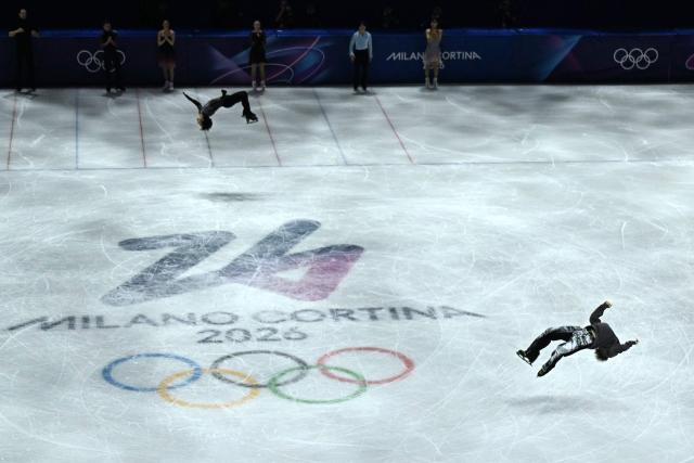USA's Ilia Malinin and France's Adam Siao Him Fa perform simultaneous backflips at the figure skating exhibition gala during the Milano Cortina 2026 Winter Olympic Games at Milano Ice Skating Arena in Milan on February 21, 2026. (Photo by Gabriel BOUYS / AFP)