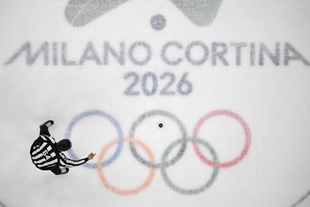 Czech referee Daniel Hynek gestures next to the puck during the men's bronze medal ice hockey match between Slovakia and Finland at the Milano Santagiulia Ice Hockey Arena during the Milano Cortina 2026 Winter Olympic Games in Milan, on February 21, 2026. (Photo by Antonin THUILLIER / AFP)