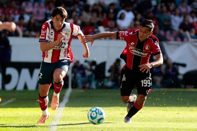 San Luis' defender #02 Roman Torres and Atlas' midfielder #199 Sergio Hernandez fight for the ball during the Liga MX Clausura football match between Atlas and San Luis at the Jalisco Stadium in Guadalajara, state of Jalisco, Mexico, on February 21, 2026. (Photo by Ulises Ruiz / AFP)