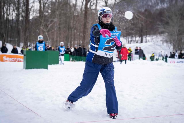 A player throws a snowball during the Showa-shinzan International Yukigassen snowball fight competition in Sobetsu, Hokkaido prefecture on February 21, 2026. At the foot of an active volcano in northern Japan, shouts ring out, competitors size each other up and snowballs whistle through the air in a very serious game of "yukigassen" -- a sport with Olympic dreams. (Photo by Yuichi YAMAZAKI / AFP) / To go with 'JAPAN-SPORT-OLY, REPORTAGE' by Mathias CENA