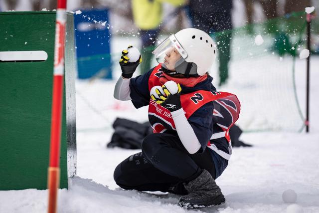 A player hides behind a shelter during a match at the Showa-shinzan International Yukigassen snowball fight competition in Sobetsu, Hokkaido prefecture on February 21, 2026. At the foot of an active volcano in northern Japan, shouts ring out, competitors size each other up and snowballs whistle through the air in a very serious game of "yukigassen" -- a sport with Olympic dreams. (Photo by Yuichi YAMAZAKI / AFP) / To go with 'JAPAN-SPORT-OLY, REPORTAGE' by Mathias CENA