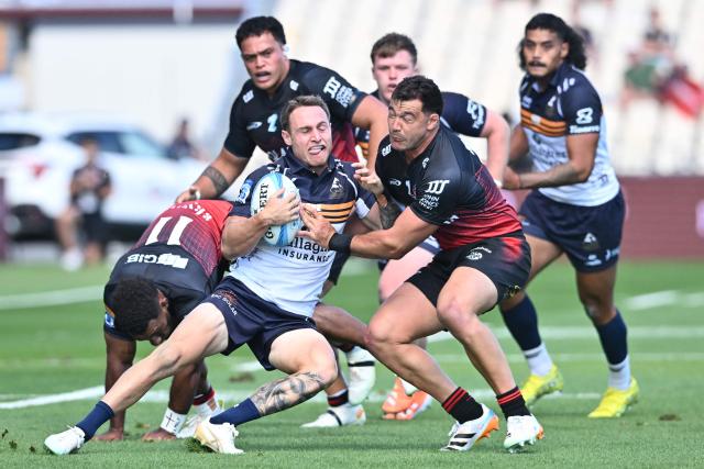 Brumbies' Corey Toole (L) is tackled by Crusaders' David Havili (R) during round two of the Super Rugby Pacific match between the Crusaders and Brumbies at Apollo Projects Stadium in Christchurch on February 22, 2026. (Photo by Sanka VIDANAGAMA / AFP)
