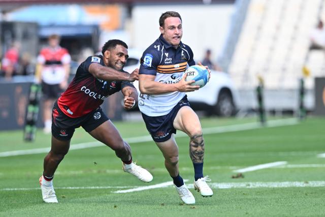 Brumbies' Corey Toole (R) runs with the ball as Crusaders' Sevu Reece attempts to tackle him during round two of the Super Rugby Pacific match between the Crusaders and Brumbies at Apollo Projects Stadium in Christchurch on February 22, 2026. (Photo by Sanka VIDANAGAMA / AFP)