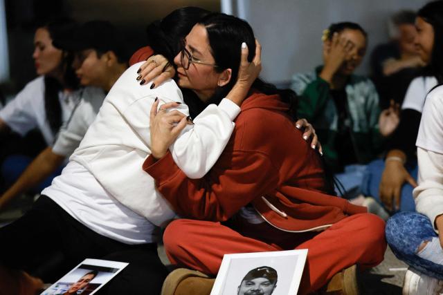 People hug each other during a vigil to demand the freedom of political prisoners outside the El Helicoide building, headquarters of the Bolivarian National Intelligence Service (SEBIN), in Caracas on February 21, 2026. Venezuelan authorities granted amnesty to 379 political prisoners on February 20, 2026 after a new mass amnesty law was enacted following the ouster of former leader Nicolas Maduro. (Photo by Pedro MATTEY / AFP)
