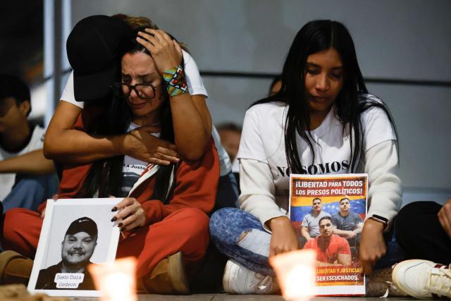 People take part in a vigil to demand the freedom of political prisoners outside the El Helicoide building, headquarters of the Bolivarian National Intelligence Service (SEBIN), in Caracas on February 21, 2026. Venezuelan authorities granted amnesty to 379 political prisoners on February 20, 2026 after a new mass amnesty law was enacted following the ouster of former leader Nicolas Maduro. (Photo by Pedro MATTEY / AFP)