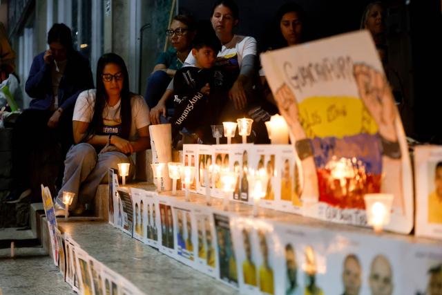 People take part in a vigil to demand the freedom of political prisoners outside the El Helicoide building, headquarters of the Bolivarian National Intelligence Service (SEBIN), in Caracas on February 21, 2026. Venezuelan authorities granted amnesty to 379 political prisoners on February 20, 2026 after a new mass amnesty law was enacted following the ouster of former leader Nicolas Maduro. (Photo by Pedro MATTEY / AFP)