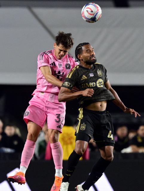 Inter Miami's US defender #32 Noah Allen (L) and LAFC's Colombian defender #04 Eddie Segura goes up for a header during the Major League Soccer opening match between Los Angeles Football Club and Inter Miami CF at the LA Memorial Coliseum in Los Angeles, on February 21, 2026. (Photo by Frederic J. Brown / AFP)