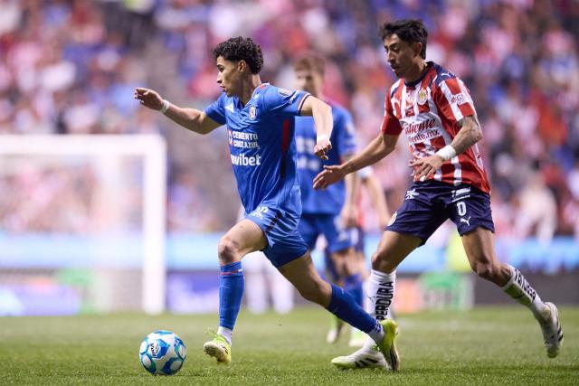 Cruz Azul's midfielder #16 Jeremy Marquez (L) runs with the ball past Guadalajara's midfielder #06 Omar Govea (R) during the Liga MX Clausura football match between Cruz Azul and Guadalajara, at the Cuauhtemoc Stadium in Puebla, state of Puebla, Mexico, on February 21, 2026. (Photo by Jacobo PEREZ / AFP)