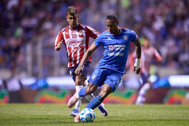 Cruz Azul's Colombian defender #04 Willer Ditta (R) runs with the ball past Guadalajara's forward #10 Efrain Alvarez (L) during the Liga MX Clausura football match between Cruz Azul and Guadalajara at the Cuauhtemoc Stadium in Puebla, Mexico on February 21, 2026. (Photo by Jacobo PEREZ / AFP)