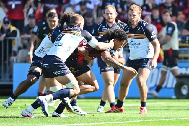 Crusaders' Leicester Fainga’anuku (C) is tackled by Brumbies' defence during round two of the Super Rugby Pacific match between the Crusaders and Brumbies at Apollo Projects Stadium in Christchurch on February 22, 2026. (Photo by Sanka VIDANAGAMA / AFP)