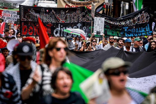 Pro-Palestinian demonstrators hold flags, banners and placards as they march through the streets during a rally in Sydney on February 22, 2026. (Photo by DAVID GRAY / AFP)
