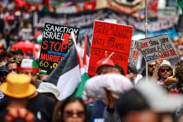 Pro-Palestinian demonstrators hold flags, banners and placards as they march through the streets during a rally in Sydney on February 22, 2026. (Photo by DAVID GRAY / AFP)