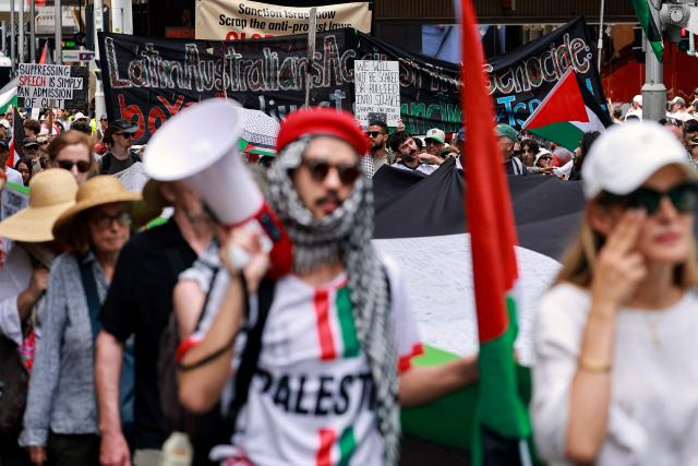 Pro-Palestinian demonstrators hold flags, banners and placards as they march through the streets during a rally in Sydney on February 22, 2026. (Photo by DAVID GRAY / AFP)