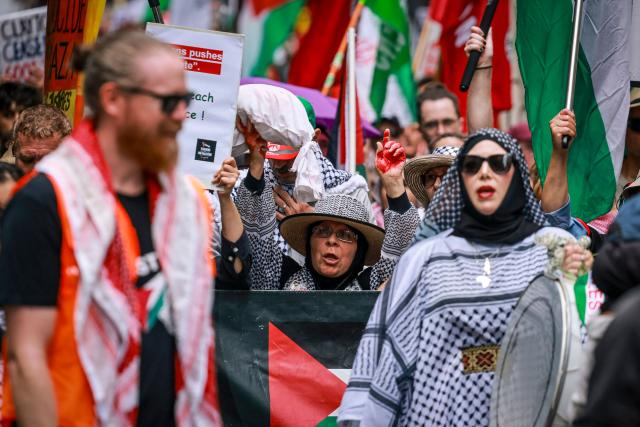 Pro-Palestinian demonstrators hold flags, banners and placards as they march through the streets during a rally in Sydney on February 22, 2026. (Photo by DAVID GRAY / AFP)