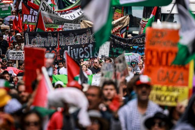 Pro-Palestinian demonstrators hold flags, banners and placards as they march through the streets during a rally in Sydney on February 22, 2026. (Photo by DAVID GRAY / AFP)