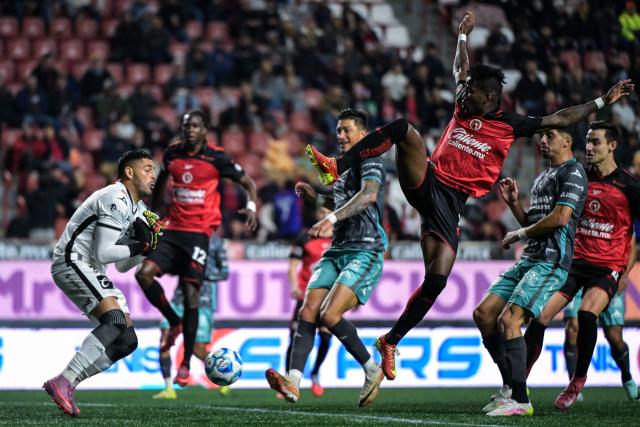 Mazatlan's goalkeeper #33 Ricardo Rodriguez (L) saves a shot by Tijuana's Ecuadorian forward #11 Adonis Preciado (3rd R) during the Liga MX Clausura football match between Tijuana and Mazatlan at the Caliente Stadium in Tijuana, Mexico on February 21, 2026. (Photo by Guillermo Arias / AFP)